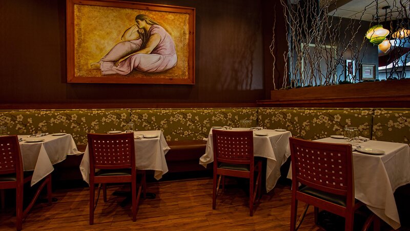 Banquette with four tables. Painting in background.